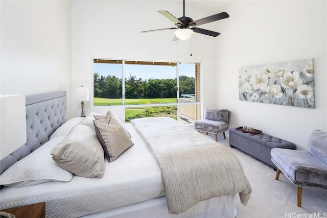 carpeted bedroom featuring a high ceiling and a ceiling fan