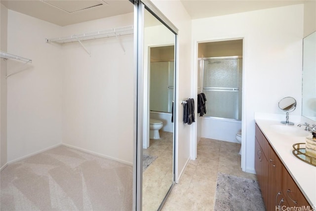 full bath featuring toilet, tile patterned floors, a walk in closet, and vanity