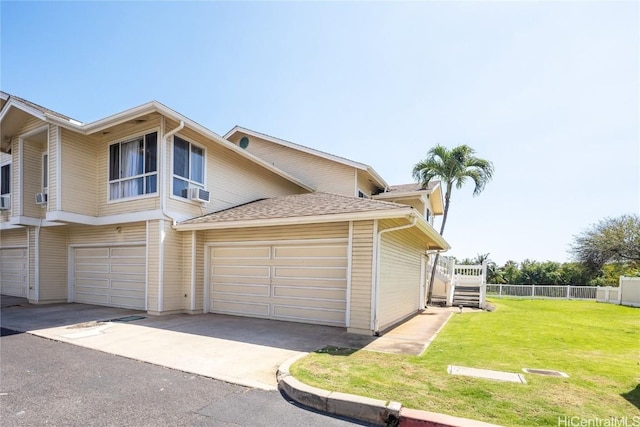 view of home's exterior with a yard, aphalt driveway, and fence