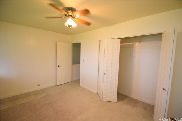 unfurnished bedroom with light colored carpet, ceiling fan, and a closet