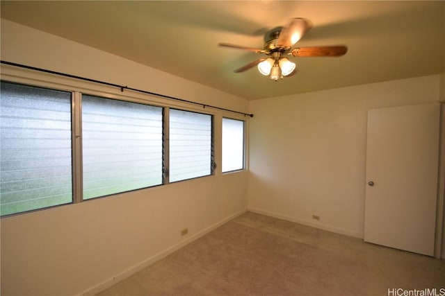 carpeted empty room with ceiling fan and a healthy amount of sunlight