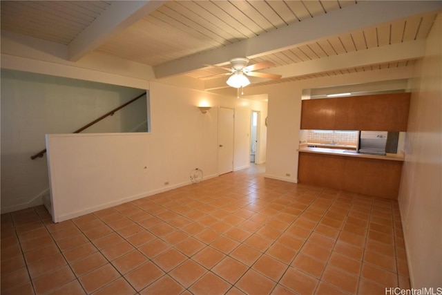 unfurnished living room with ceiling fan, beamed ceiling, and light tile patterned flooring