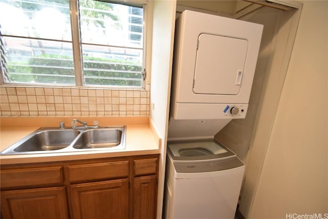 washroom featuring stacked washer and dryer and sink