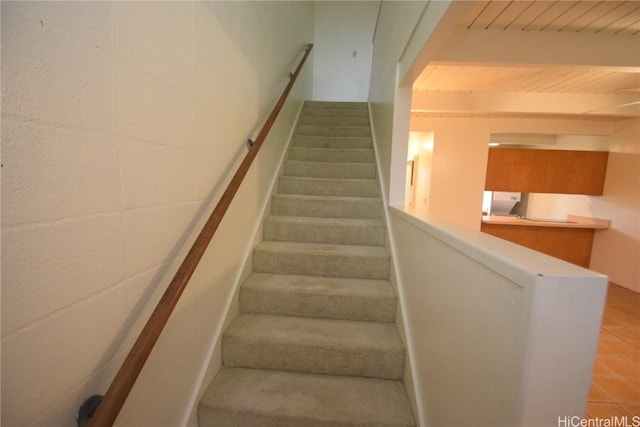 stairway featuring wood ceiling and beam ceiling