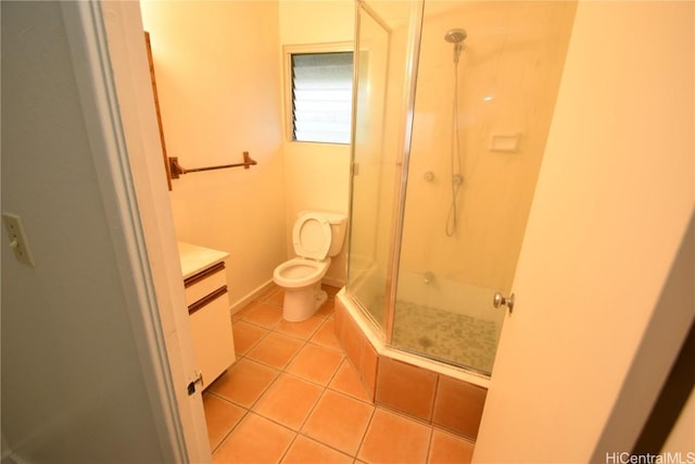 bathroom with tile patterned flooring, vanity, a shower with door, and toilet