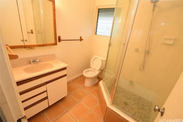 bathroom featuring tile patterned flooring, vanity, toilet, and walk in shower