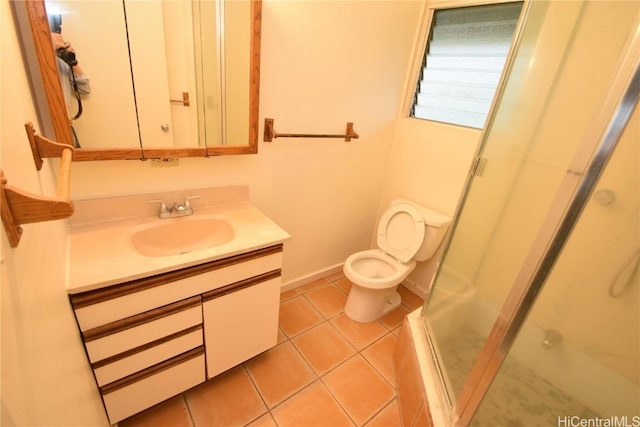 bathroom with walk in shower, vanity, toilet, and tile patterned flooring