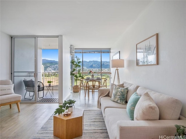 living room with a mountain view, wood-type flooring, and expansive windows