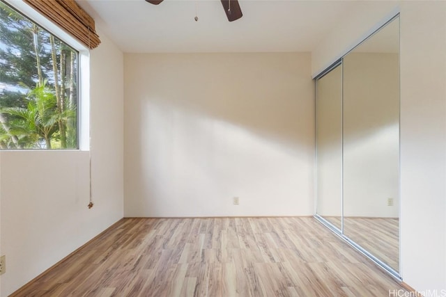 unfurnished bedroom with a closet, ceiling fan, and light wood-type flooring