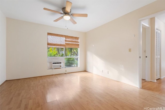 empty room featuring ceiling fan, cooling unit, and light wood-type flooring