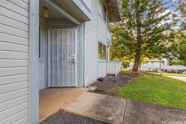 view of exterior entry with a yard