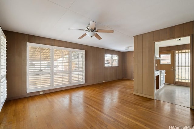 empty room with ceiling fan, a healthy amount of sunlight, and light wood-type flooring