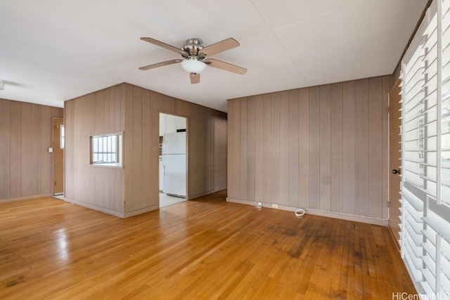 empty room with ceiling fan and light hardwood / wood-style floors