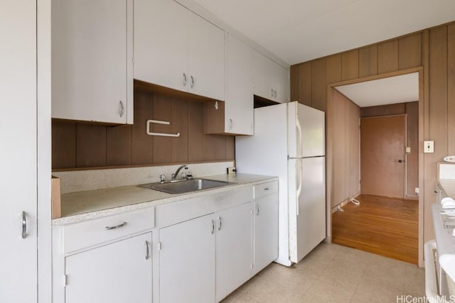 kitchen featuring sink, white fridge, and white cabinets