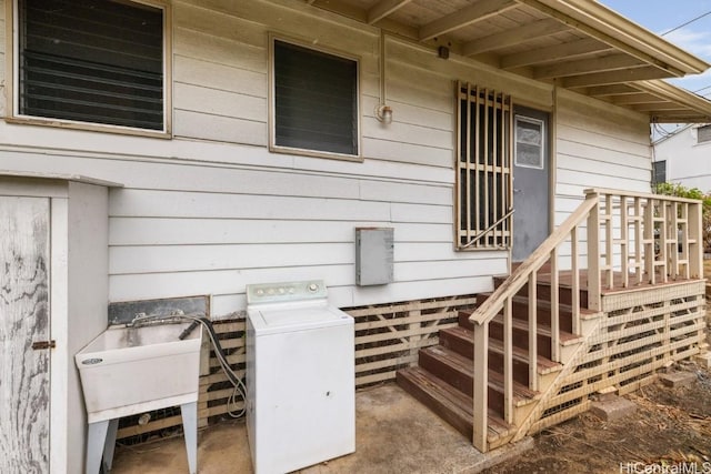 property entrance featuring washer / clothes dryer and sink