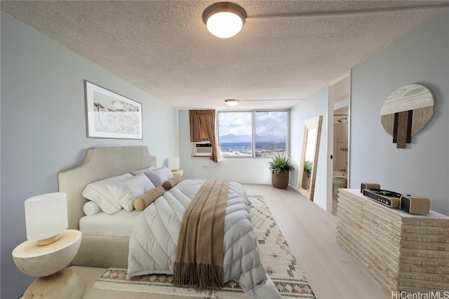 bedroom with floor to ceiling windows, hardwood / wood-style floors, a textured ceiling, and cooling unit