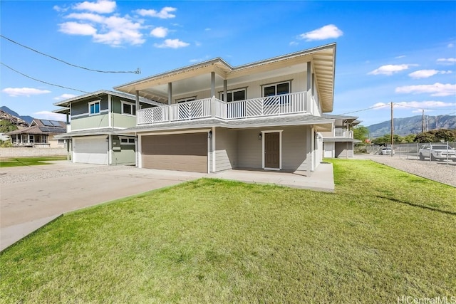 view of front of property with a balcony, a garage, and a front yard