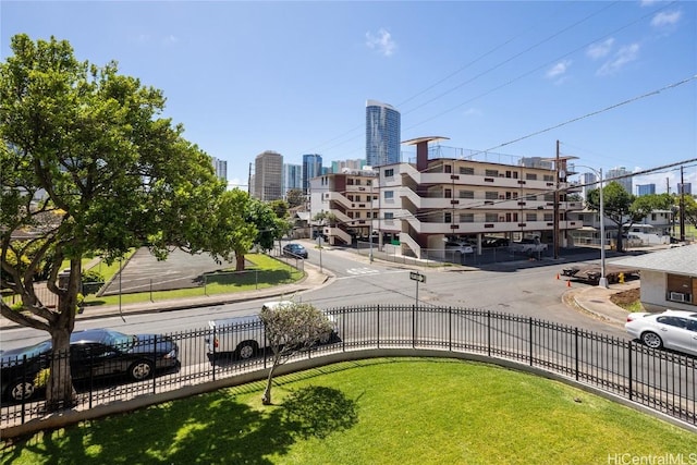 view of home's community featuring fence and a city view