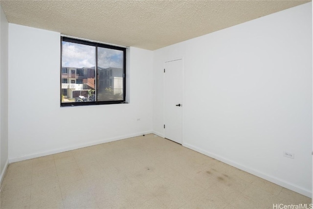 unfurnished room with baseboards, a textured ceiling, and tile patterned floors