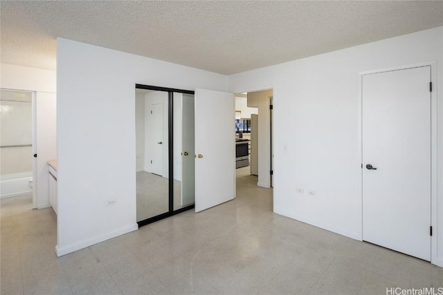 unfurnished bedroom with a textured ceiling and baseboards