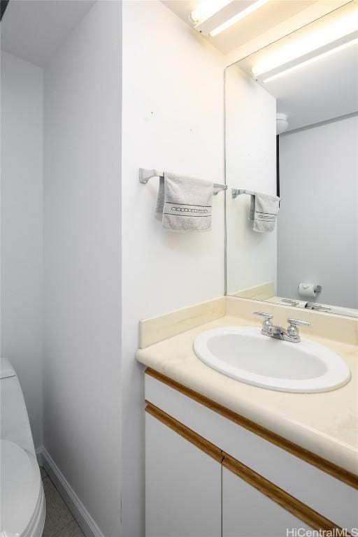 bathroom featuring baseboards, vanity, and toilet