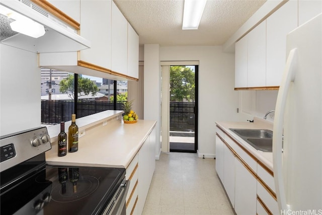 kitchen with under cabinet range hood, a sink, white cabinets, electric stove, and freestanding refrigerator