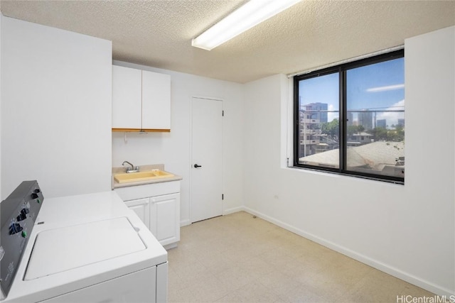 washroom featuring light floors, cabinet space, a sink, independent washer and dryer, and baseboards