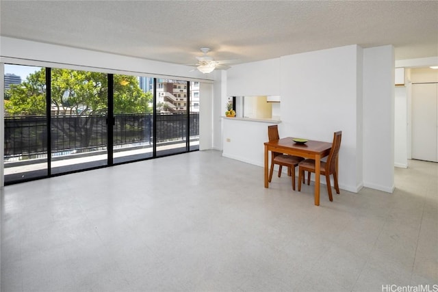 dining space featuring baseboards, ceiling fan, a textured ceiling, and light floors