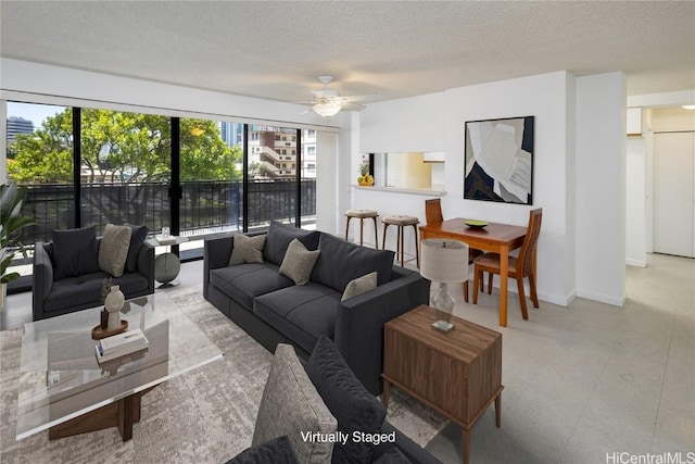 living room featuring baseboards, a textured ceiling, and tile patterned floors