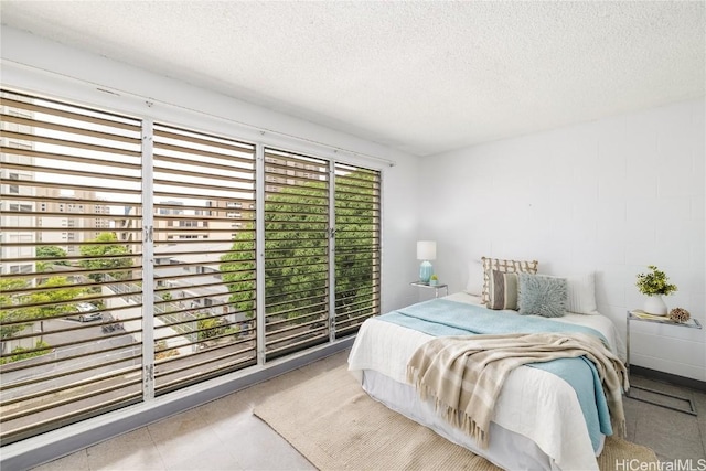 bedroom featuring multiple windows and a textured ceiling