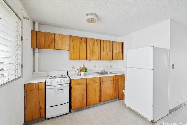 kitchen with white appliances, sink, and a textured ceiling