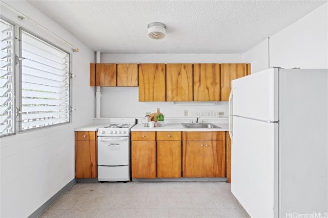 kitchen featuring white appliances, sink, and a textured ceiling