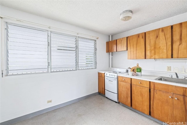 kitchen with sink, electric range, and a textured ceiling