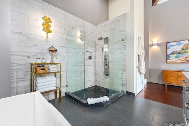 bathroom featuring walk in shower, a towering ceiling, and tile patterned flooring