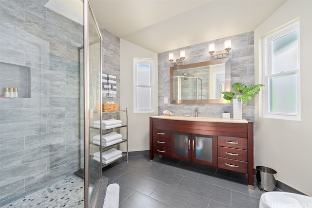 bathroom featuring vanity, vaulted ceiling, tile patterned floors, and walk in shower