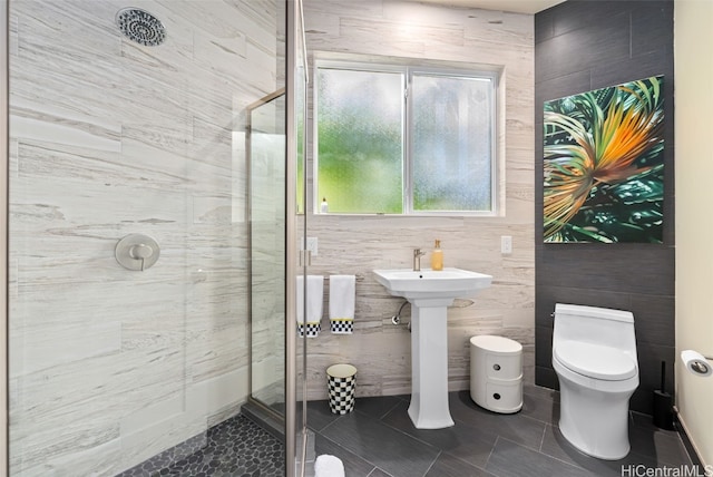 bathroom with walk in shower, sink, tile patterned floors, and toilet