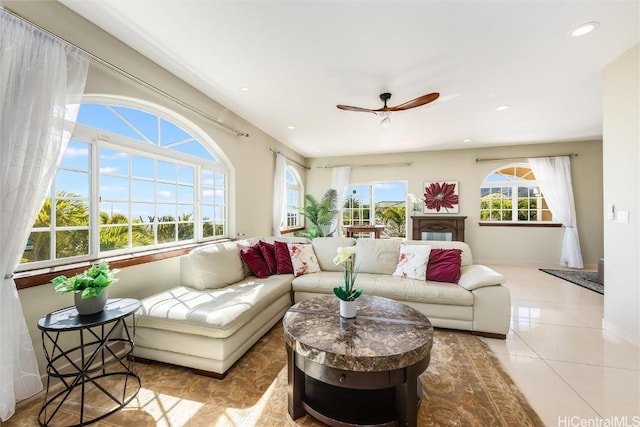 living room featuring plenty of natural light, light tile patterned floors, and ceiling fan