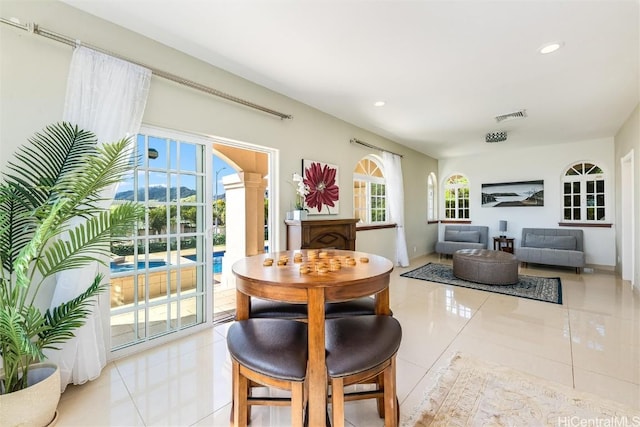 dining space featuring ornate columns and light tile patterned floors