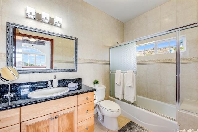 full bathroom featuring enclosed tub / shower combo, tile walls, tile patterned flooring, vanity, and toilet