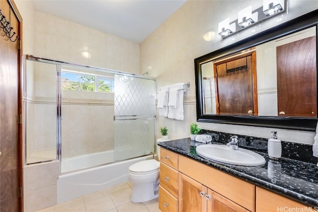 full bathroom with vanity, tile patterned floors, shower / bath combination with glass door, and toilet