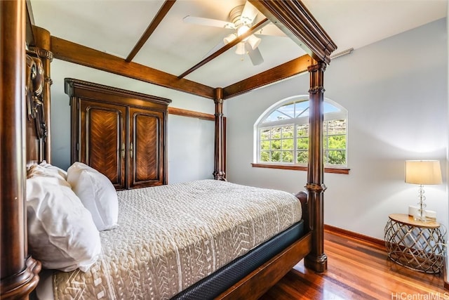 bedroom with beamed ceiling, wood-type flooring, and ceiling fan