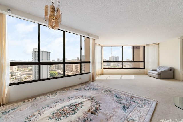 spare room featuring light carpet and a textured ceiling