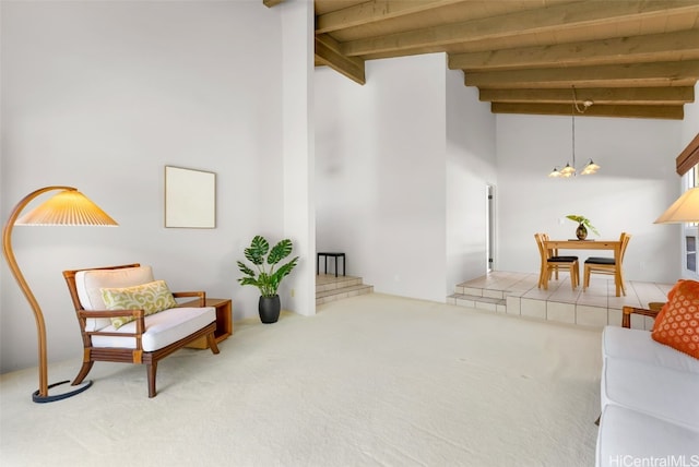 living area featuring beamed ceiling, a high ceiling, carpet floors, and a notable chandelier