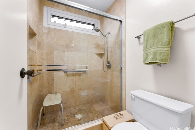 bathroom with toilet and a shower with shower door