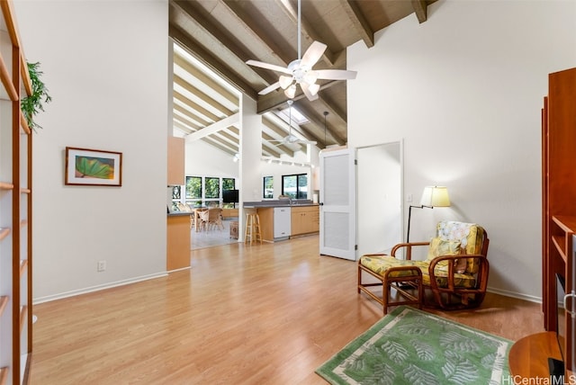 living area with sink, high vaulted ceiling, light wood-type flooring, beamed ceiling, and ceiling fan