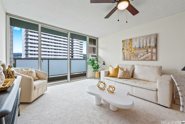 living room featuring ceiling fan, light carpet, and a textured ceiling