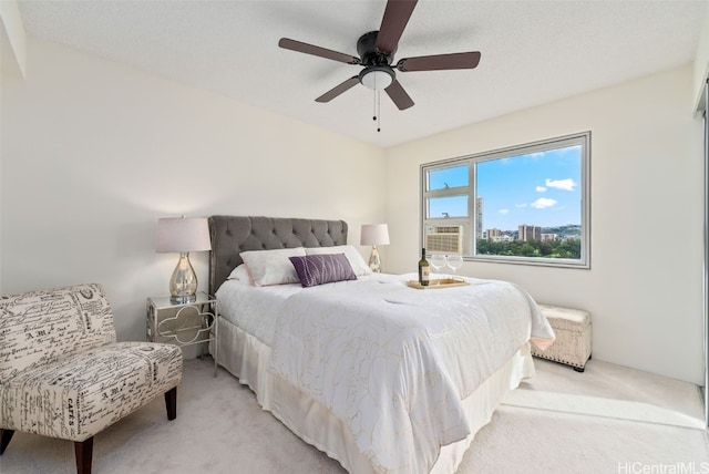 bedroom with light colored carpet, ceiling fan, and cooling unit