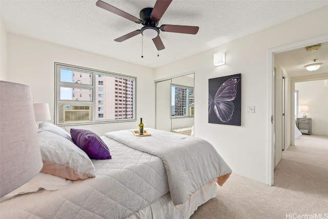 carpeted bedroom featuring cooling unit, a closet, ceiling fan, and a textured ceiling