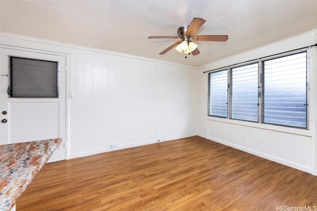 unfurnished room with wood-type flooring, ornamental molding, and ceiling fan