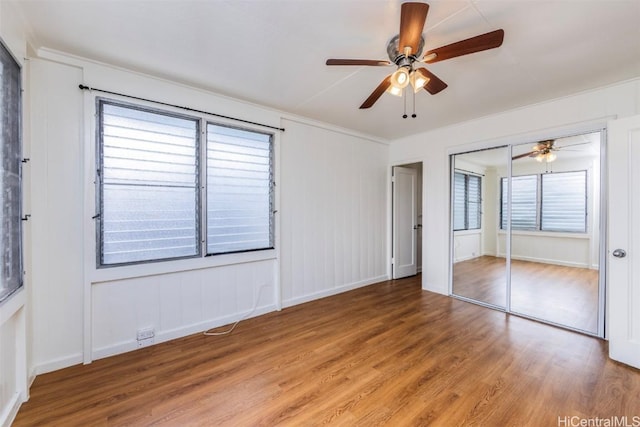 unfurnished bedroom featuring hardwood / wood-style flooring, ceiling fan, and a closet